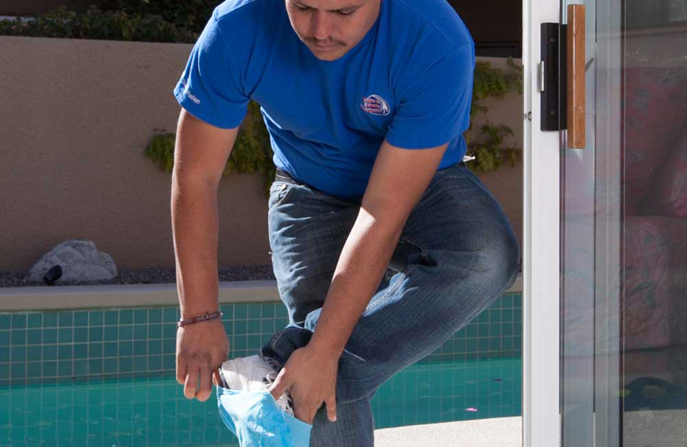 A Brite and Clean technician puts covers on their shoes when entering the home.